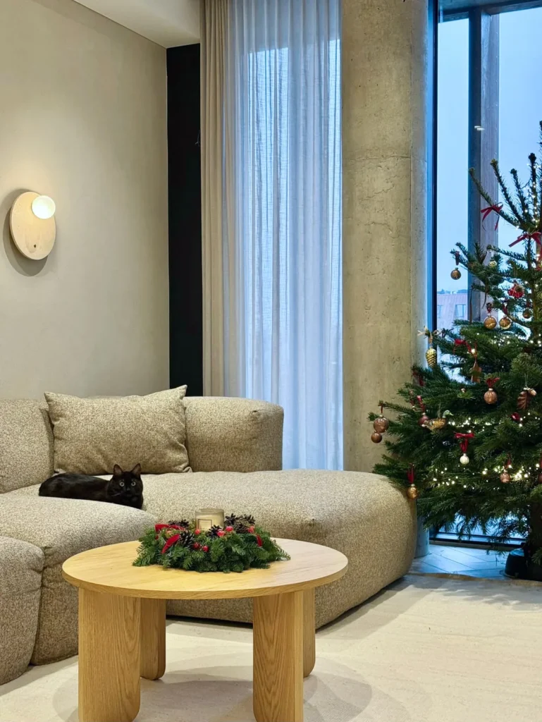 Svetainė su sofa ir apvaliu staliuku – minimalistinis butas Kaune